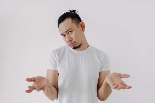 Shrug whatever face Asian man in white t-shirt isolate on white.