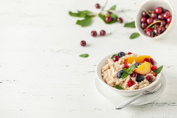 Oatmeal cereal with berries in a bowl on the table. A healthy breakfast. Baby food.