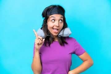 Young caucasian woman with Inflatable Travel Pillow isolated on blue background intending to realizes the solution while lifting a finger up