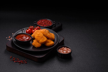 Delicious fresh crispy chicken nuggets on a dark concrete background