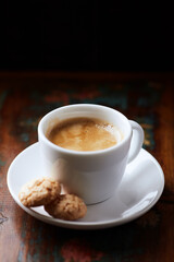 Cup of coffee and Amaretti (Italian biscuits) on rustic wooden background. Rustic wooden background.