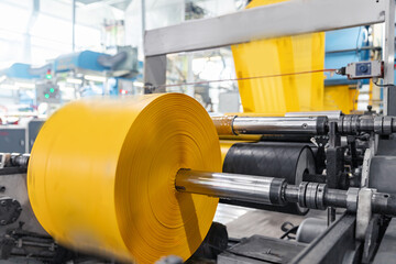 Polyethylene plastic bag production, sunlight. Closeup roller of industry machine for packaging