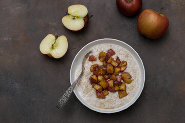 A warm bowl of oatmeal topped with caramelized apples, perfect for a cozy breakfast.