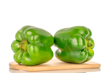 Two sweet green peppers on a wooden kitchen board, close-up, isolated on a white background.