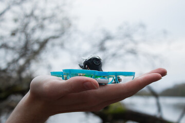 A series of photos showcasing the process of preparing and operating a small FPV drone outdoor. The...