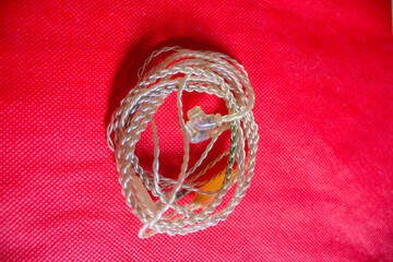An In Ear Monitoring cable is photographed on a plain red cloth.
Pinrang, South Sulawesi...