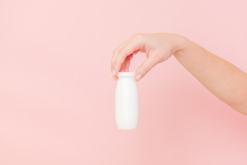 Hand holding bottle of probiotic yogurt for digestive system. Dietary supplements for stomach