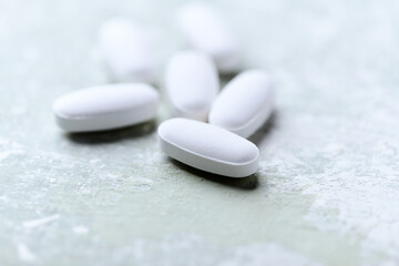 White tablets on wooden background. Soft focus. Close up. Copy space
