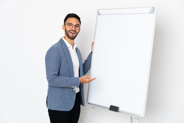 Young caucasian man isolated on white background giving a presentation on white board