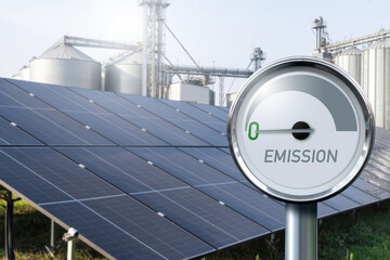 Modern farm using renewable energy. Solar panels with silos in the background.. © scharfsinn86