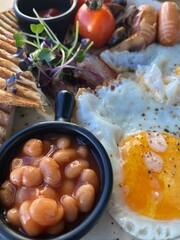 delicious breakfast with eggs, sausages, salad, croissants, tomatoes and cheese