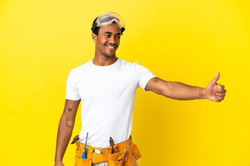 African American electrician man over isolated yellow wall giving a thumbs up gesture