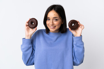 Fototapeta premium Young caucasian woman isolated on white background holding donuts