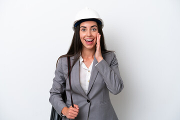 Young architect caucasian woman with helmet and holding blueprints isolated on white background with surprise and shocked facial expression