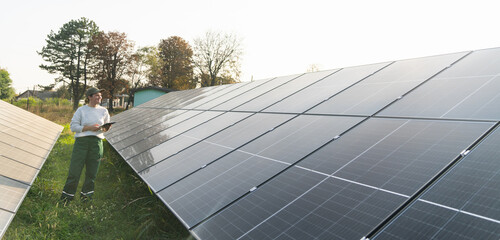 Female farmer with digital tablet on a modern farm using solar panels.