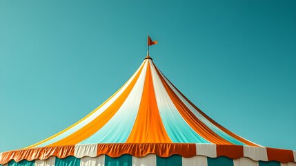 Colorful striped circus tent top against a clear blue sky, featuring orange, white, and teal vertical stripes with a central pointed top.