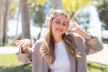 Pretty blonde Uruguayan woman listening music and dancing