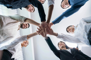 Bottom view spiral round hand made by diverse office worker or business people join hand together...