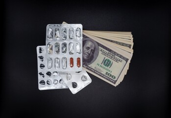 empty blisters with two capsules of medicine lie on dollar bills