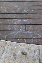 Children's chalk drawings on the sidewalk in the city.