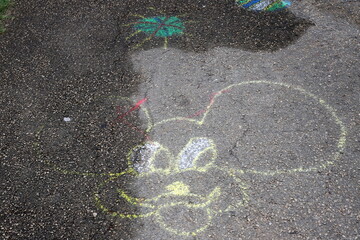 Children's chalk drawings on the sidewalk in the city.