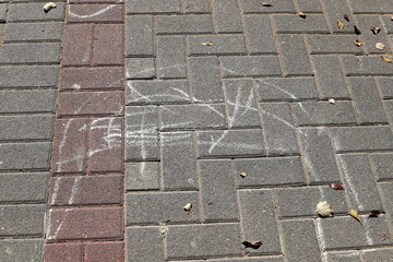 Children's chalk drawings on the sidewalk in the city.