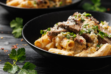Philly cheese steak pasta in black bowl