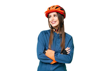Young cyclist woman over isolated chroma key background looking up while smiling