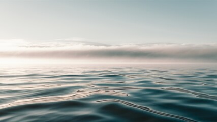 Obraz premium Serene Ocean Horizon: A captivating view of the ocean's surface stretching towards the horizon, shrouded in a misty haze under a soft, ethereal sky. 