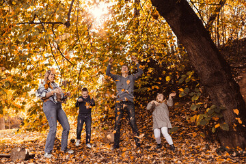 Fototapeta premium Family Playing In Autumn Leaves