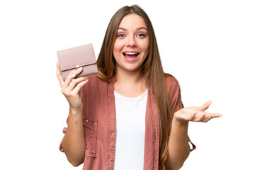 Young blonde woman holding a wallet over isolated chroma key background with shocked facial...