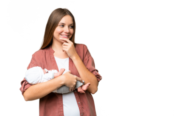 Young blonde woman  with her newborn baby over isolated chroma key background thinking an idea and looking side