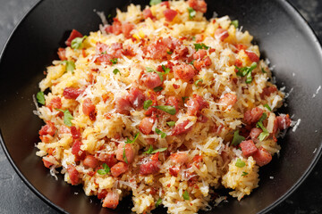Carbonara fried rice with pancetta, pecorino romano cheese, eggs in a black bowl