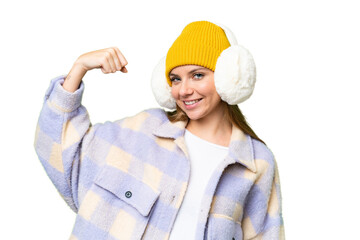 Young blonde woman wearing winter muffs over isolated chroma key background doing strong gesture