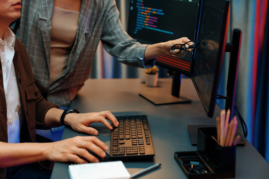 IT developers discussing with point to intelligent website development coder system running data online two screens information technology at neon light room at modern office. Infobahn.