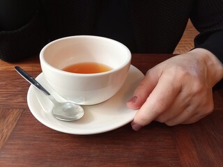 Hands holding mug of hot drink, close-up