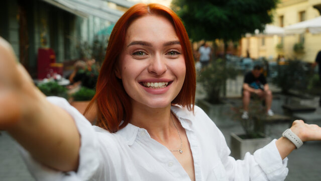 Caucasian woman girl female tourist traveler vlogger blogger influencer social media record video selfie talk mobile phone camera chat outdoors city cafe travel blog channel online stream webcam view