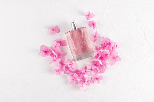Elegant pink perfume bottle surrounded by delicate flowers