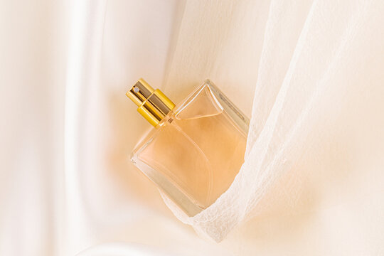Elegant glass perfume bottle with golden accents on silk