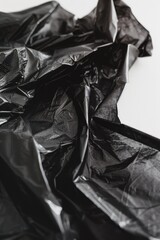 A pair of scissors sitting on top of a black plastic bag, ready for use