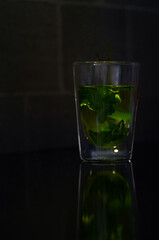 A fresh cup of mint tea on a dark, minimalist background. Ideal for food and drink blogs, health and wellness features, or product photography for tea brands.