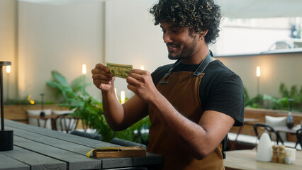 Happy Indian Arabian man guy male waiter cafe worker cleaner small business owner joyful barista in...