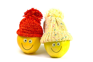 Äpfel mit Gesicht und Pudelmütze vor weißem Hintergrund