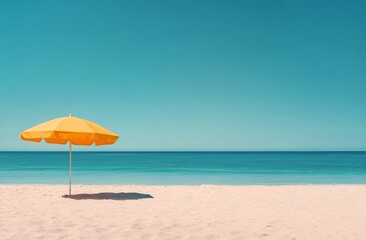 A bright yellow umbrella on a serene beach under a clear blue sky in midday light