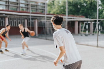 A group of friends playing basketball on an old neighborhood court. They are enjoying the sunny day, displaying teamwork, and engaging in energetic competition and fun.