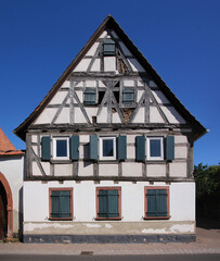 A decaying half-timbered wooden residential house with its symmetrical gable in the old village of Herxheim bei Landau, Pfalz region in Germany