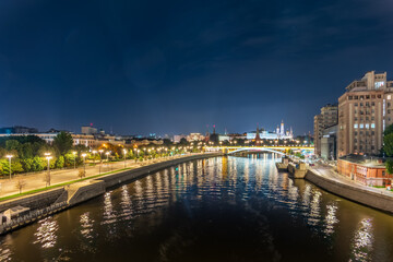 Naklejka premium Illuminated Moscow Kremlin and Bolshoy Kamenny Bridge at summer night. View from the Patriarshy pedestrian Bridge