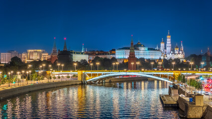 Naklejka premium Illuminated Moscow Kremlin and Bolshoy Kamenny Bridge at summer night. View from the Patriarshy pedestrian Bridge