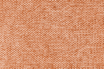 Mixed white and orange color melange knitted fabric, cashmere wool cloth texture. Background of knit fabric, jersey textile structure, cloth surface, weaving of knitwear material.