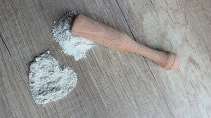 Zeolite mesolite raw powder on wooden background. Zeolite in a wooden mortar with a pestle.